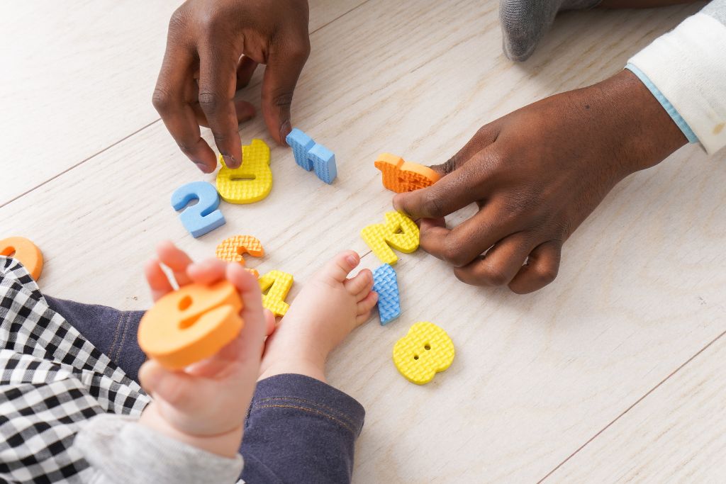 Kids playing with letters and numbers. A photo of a blogpost How to teach toddlers to share