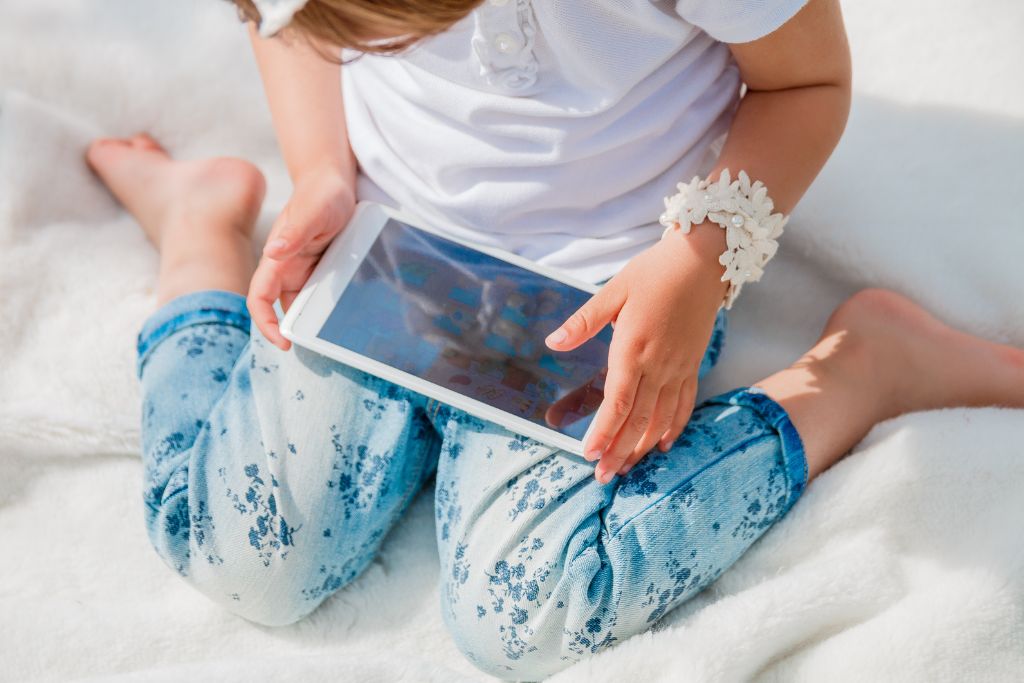 Child with an ipad. Photo of a blog post How to reduce screen time without tantrums