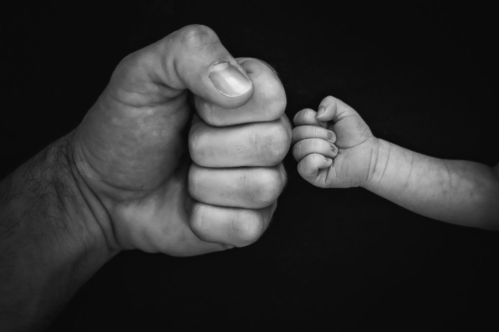 Child's and parent's fists bumping. Photo of a blog post Why is my child hitting me?